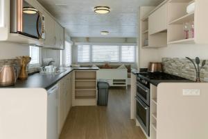 a kitchen with white cabinets and a counter top at Golden Gate Holiday Centre - Holiday Accommodation 19058 in Kinmel Bay +3 photos