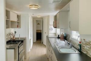 a kitchen with a sink and a counter top at Golden Gate Holiday Centre - Holiday Accommodation 19058 in Kinmel Bay