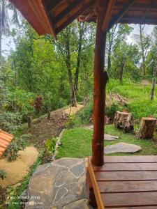 a porch with a wooden bench in a garden at Pengaringan Cottage Cotol in Gitgit