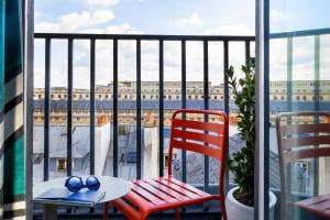a table and chairs on a balcony with a view of a building at Hôtel Aoriste & Spa in Paris
