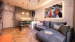 a living room with a couch and a dining room at Flatbook - City Centre Granaria II & SPA in Gdańsk