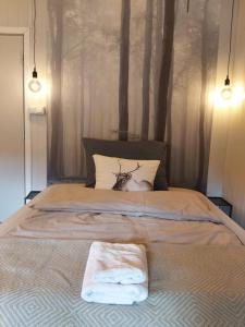 a bed with two towels sitting on top of it at Varangertunet Wilderness resort in Jakobselv