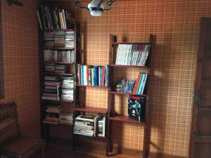 ein Bücherregal gefüllt mit Büchern in einem Raum in der Unterkunft Chaleureuse Maison de Montagne in Garin