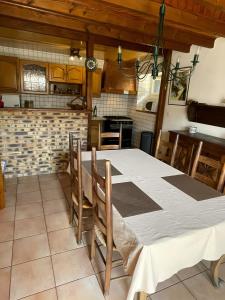 eine Küche mit einem großen weißen Tisch mit Stühlen in der Unterkunft Chaleureuse Maison de Montagne in Garin