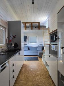 a kitchen and living room with a couch in a tiny house at TinyHousebeiDresden klein aber fein, beste Alleinlage direkt am Naturteich, große Terrasse - Nähe Sächsische Schweiz und Dresden in Großharthau