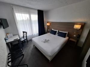 沙朗Cit'Hôtel Le Quai 9 , ex Le Challans的有一张大床和一扇窗户的酒店房间