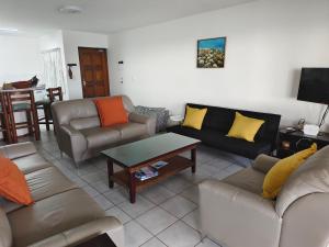 a living room with couches and a coffee table at Laguna la crete 45,Uvongo in Uvongo Beach
