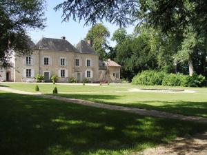 an old house with a large lawn in front of it at Chambres d'hôtes Saint Denis in Mézières-sur-Issoire