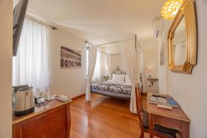 ヴェローナにあるRelais Ristoriのベッド、机、鏡付きのテーブルがある寝室