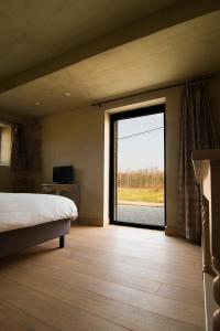 a bedroom with a bed and a large sliding glass door at B&B de ZIL in Herselt +108 photos