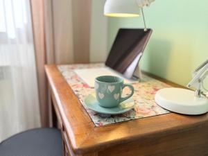a coffee cup sitting on a table with a laptop at ROSMARINO - Comodità e tranquillità con Giardino e Parcheggio in Imperia