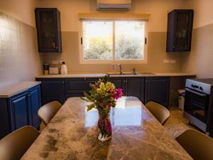 Una cocina con una mesa con un jarrón de flores encima. en Windmill Hostel, en San Julián