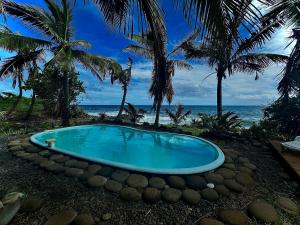 una piscina sulla spiaggia con palme di Gerard chantal a Saint-Pierre