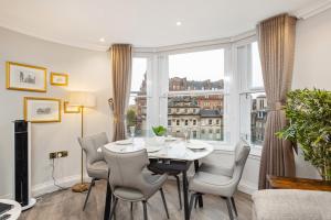 a dining room with a table and chairs and a large window at Central Edinburgh Prime Luxury in Edinburgh