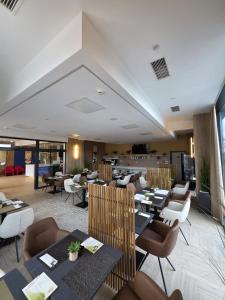un ristorante con tavoli e sedie in una stanza di Hotel Cat Deluxe a Sanski most Altre 27 foto