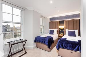 a bedroom with two beds and a window at Central Edinburgh Prime Luxury in Edinburgh