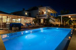 a swimming pool in front of a house at night at Villa Arancia in Pigi +127 photos
