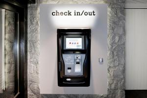 a check in machine with the words check in out at Morosani Fiftyone - the room only Hotel in Davos