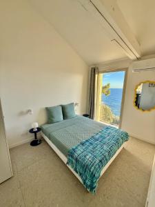 Un dormitorio con una cama y una ventana grande en Casa Favelas, Vue Mer et Proche de Monaco, en Cap d'Ail