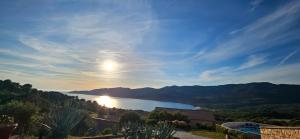 einen Blick auf einen See mit der Sonne am Himmel in der Unterkunft Chaleureux T2 Vue mer et piscine Alba Rossa in Serra-di-Ferro