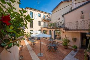 an outdoor patio with an umbrella and tables and chairs at Relais Ristori in Verona