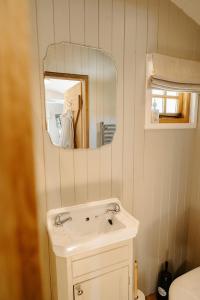 Un baño con un lavabo blanco y un espejo. en Lambourne Hut By Birch Stays, en Chirk 12 fotos más