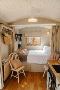 Un dormitorio con una cama, un escritorio y una silla. en Lambourne Hut By Birch Stays, en Chirk