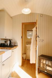 una cocina con una puerta abierta a un baño en Lambourne Hut By Birch Stays, en Chirk