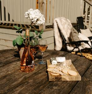 una mesa con una botella de vino y un plato de galletas en Lambourne Hut By Birch Stays, en Chirk