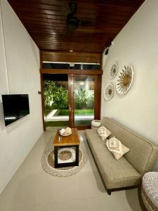 a living room with a couch and a table at Villa Licia - Seseh area in Balian