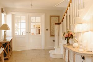 un pasillo con una escalera y un jarrón de flores sobre una mesa en Lambourne House By Birch Stays, en Chirk 43 fotos más