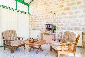 a living room with two chairs and a table at L'amandier à blajoux in Montbrun