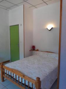 a bedroom with a bed with a green door at L'amandier à blajoux in Montbrun