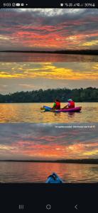 バルカラにあるHridhayam Homestay varkalaの夕暮れ時の水上でカヤックに乗った二人