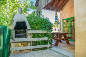 a outdoor grill with a picnic table next to a building at Le chardon à blajoux in Montbrun