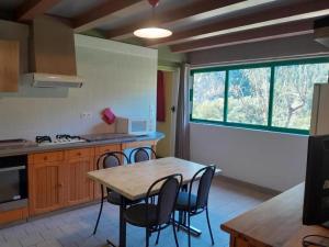 a kitchen with a table and chairs and a window at Le chardon à blajoux in Montbrun