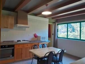 a kitchen with a table and chairs and a window at Le chardon à blajoux in Montbrun +10 photos