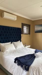 a bedroom with a large bed with a blue headboard at The N1 Farm Place in Pretoria +59 photos