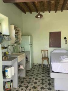 a kitchen with a bed and a table and a refrigerator at MYRTIA , Traditional Kimolos house in Kimolos