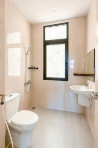 富国Ju-Jo Homestay的带马桶、水槽和窗户的浴室