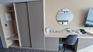 a room with a desk and a mirror at Suncity Hotel & SPA in Šiauliai