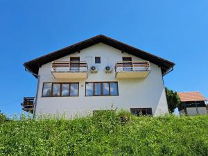 a white house with windows on top of a hill at Guesthouse Zafran in Smoljanac +13 photos