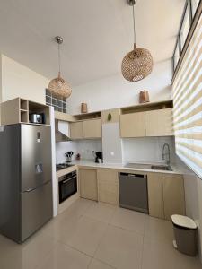 a kitchen with stainless steel appliances and two pendant lights at Golden Sunset - Appart'Hôtel -Vue sur la ville in Antananarivo