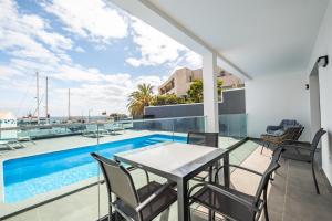 un balcón con mesa y sillas junto a una piscina en Golden Home IV, en Caniçal