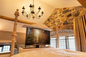 a bedroom with a chandelier and a stone wall at Old School House, Halkyn in Halkyn