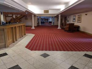 a large room with a red rug on the floor at Urban Hotel in Grantham