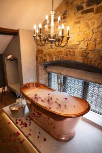 a large wooden bath tub covered in confetti in a bathroom at Old School House, Halkyn in Halkyn +228 photos