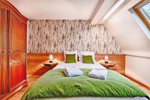 une chambre avec un grand lit vert et deux lampes dans l'établissement Chalet Les Terrasses d'Albé 6P Montages & Vignes, à Albé