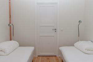 乌普萨拉Cottage in forest的一间白色的房间,设有两张床和一扇门