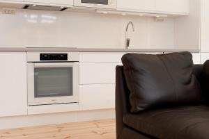 乌普萨拉Cottage in forest的厨房里有一张沙发，旁边还有水槽和微波炉。